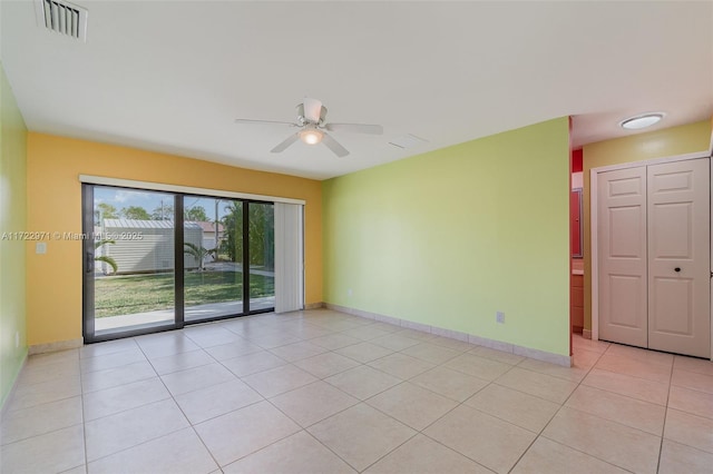 tiled empty room featuring ceiling fan