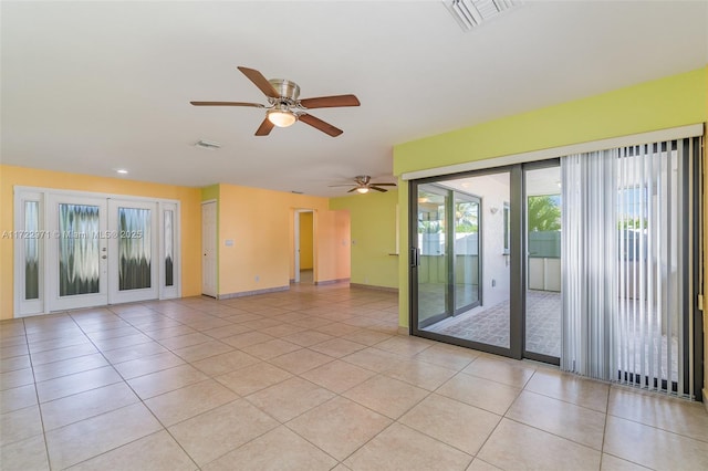 tiled spare room with ceiling fan and french doors