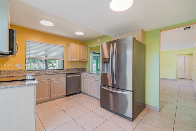 kitchen featuring appliances with stainless steel finishes, light tile patterned floors, and sink