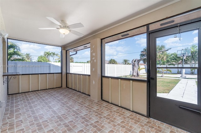 unfurnished sunroom featuring ceiling fan