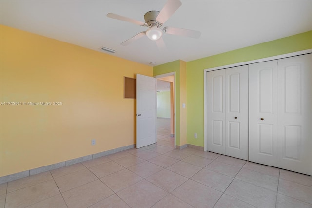 unfurnished bedroom with ceiling fan, light tile patterned floors, and a closet