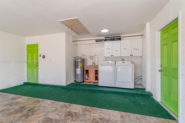 laundry area featuring washer and dryer, electric water heater, and cabinets