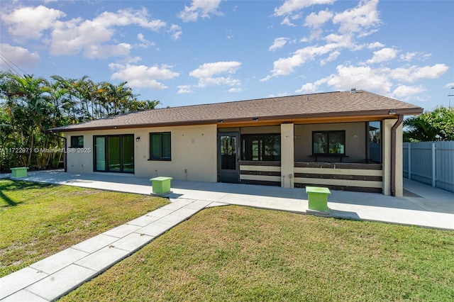 rear view of property featuring a lawn and a patio area