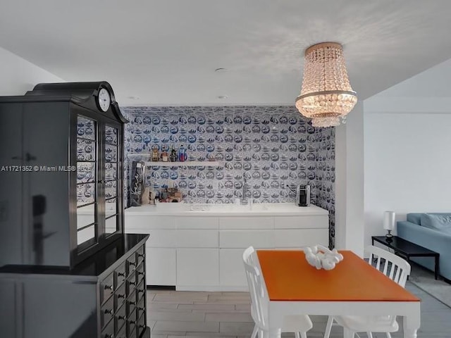 dining area featuring sink, a chandelier, and light wood-type flooring