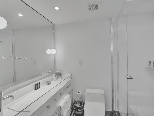 bathroom with vanity, a shower with shower door, and toilet