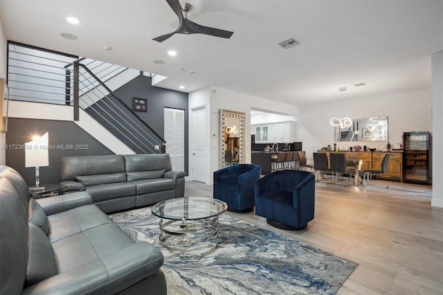 living room featuring recessed lighting, visible vents, stairway, light wood-style floors, and a ceiling fan