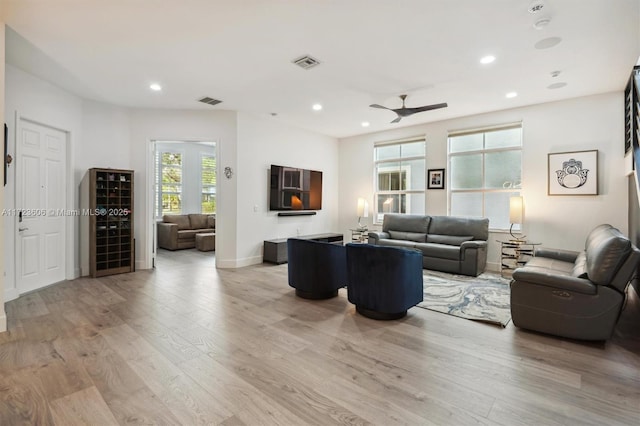 living room featuring light wood-type flooring, ceiling fan, and beverage cooler