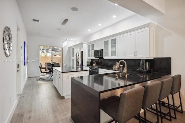 kitchen featuring a center island, white cabinets, a kitchen breakfast bar, kitchen peninsula, and stainless steel appliances