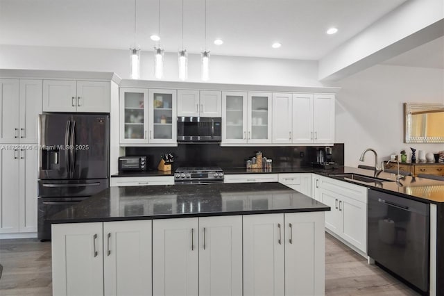 kitchen featuring pendant lighting, sink, decorative backsplash, white cabinetry, and stainless steel appliances