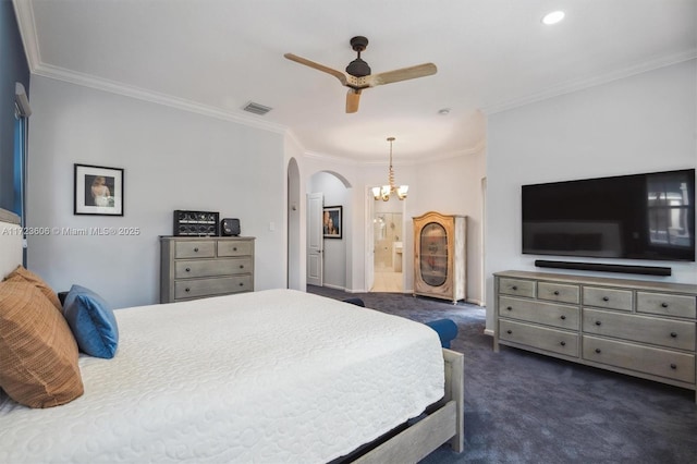 bedroom with dark colored carpet, ceiling fan with notable chandelier, crown molding, and ensuite bath