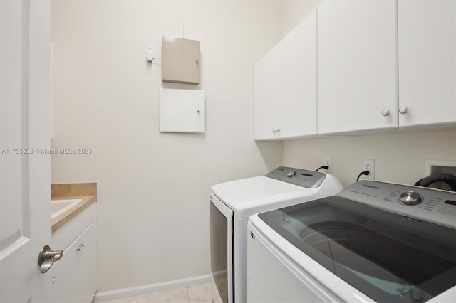 washroom with cabinets, light tile patterned floors, and washer and clothes dryer