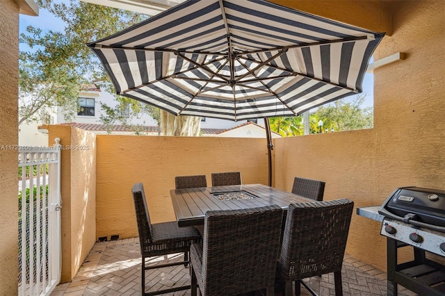 view of patio featuring outdoor dining area, a fenced backyard, and a grill