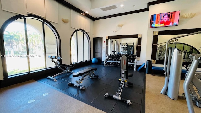 gym featuring plenty of natural light, crown molding, and recessed lighting