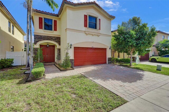 mediterranean / spanish home with a front yard and a garage