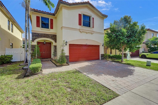 mediterranean / spanish-style home with a garage and a front yard