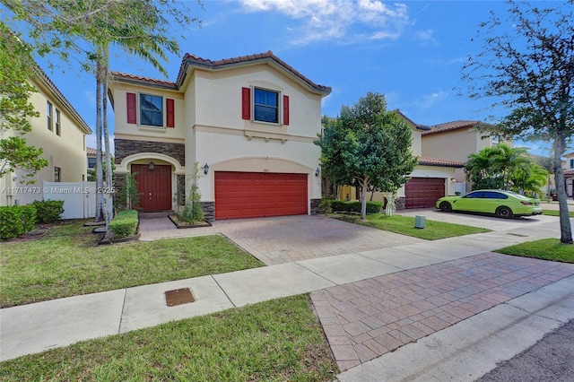 mediterranean / spanish house with a garage and a front lawn