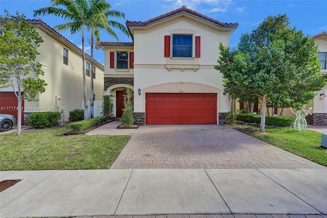 mediterranean / spanish-style house featuring a garage and a front lawn