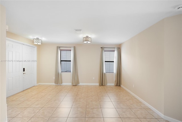 empty room featuring a wealth of natural light and light tile patterned flooring