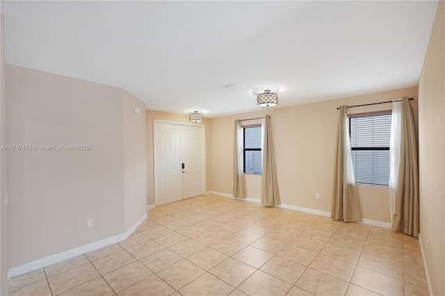 spare room with light tile patterned floors and a wealth of natural light