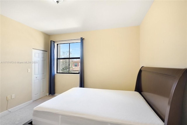 bedroom featuring light colored carpet and a closet