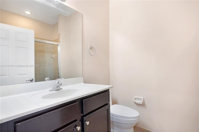 bathroom featuring an enclosed shower, vanity, and toilet