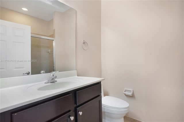 bathroom featuring walk in shower, vanity, and toilet