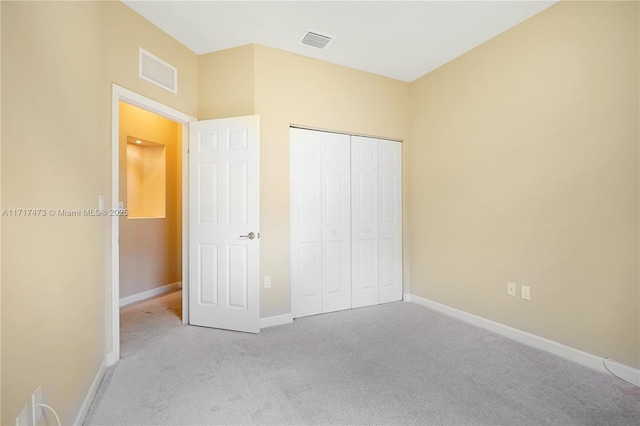 unfurnished bedroom with a closet and light carpet