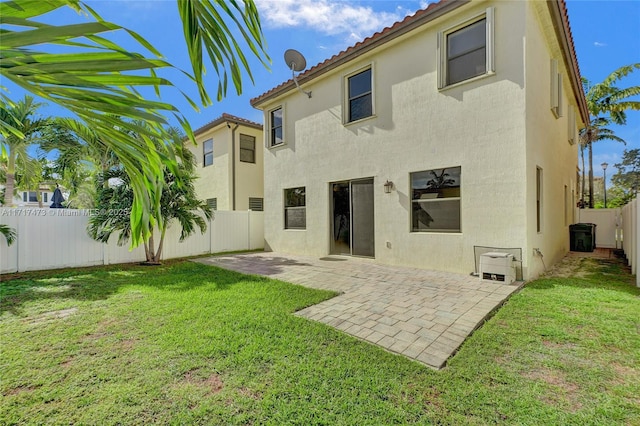 rear view of property featuring a yard and a patio