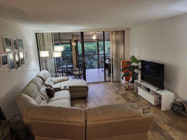 living room with hardwood / wood-style flooring, expansive windows, and a textured ceiling