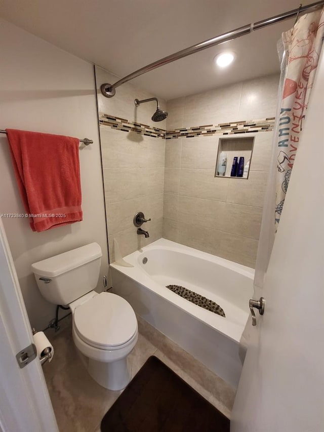 bathroom with shower / tub combo with curtain, tile patterned floors, and toilet