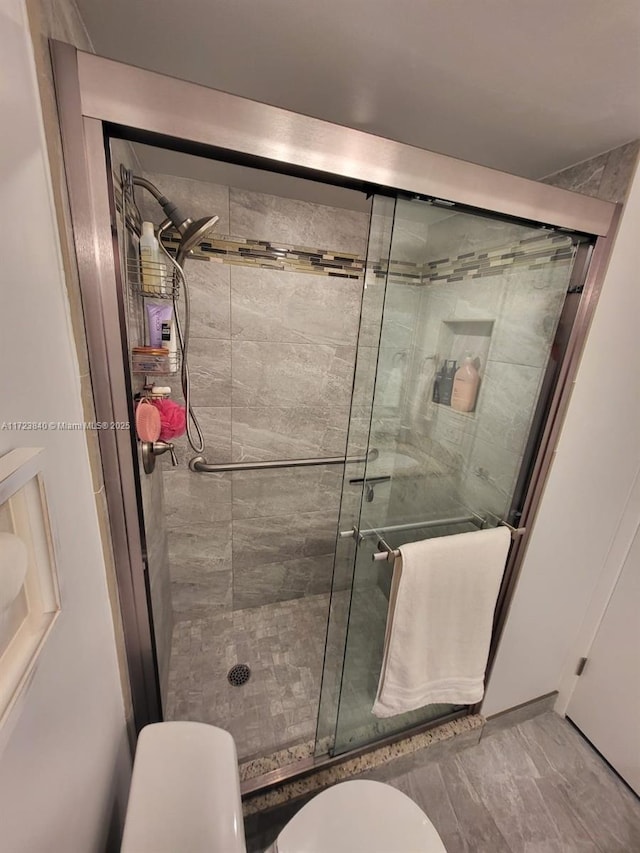 bathroom featuring toilet and an enclosed shower