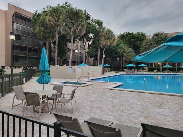 view of swimming pool with a hot tub and a patio area