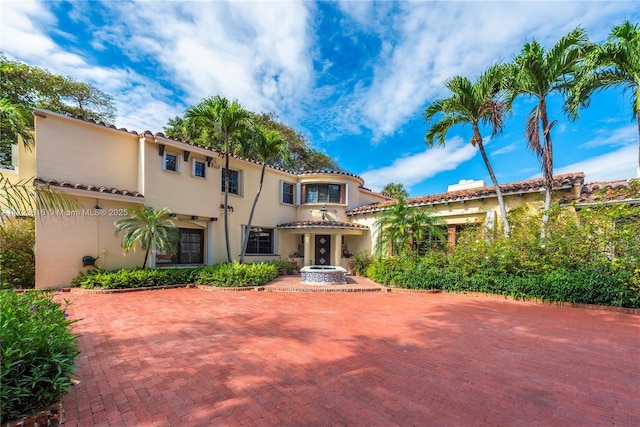 view of front facade featuring a tiled roof and stucco siding