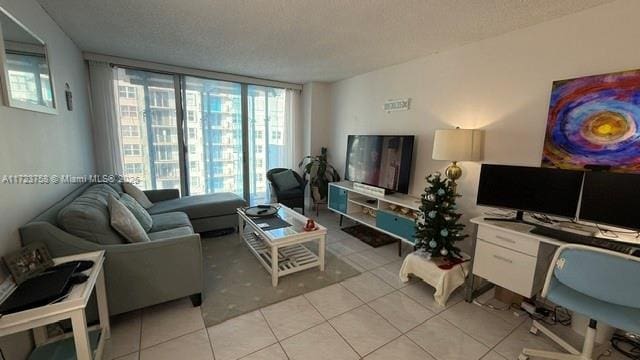 tiled living room with a textured ceiling and floor to ceiling windows