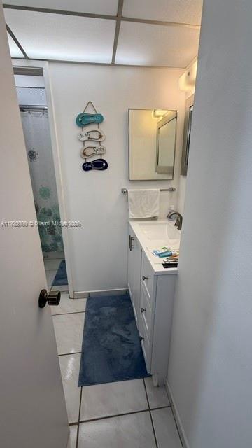 bathroom featuring tile patterned floors, vanity, and curtained shower