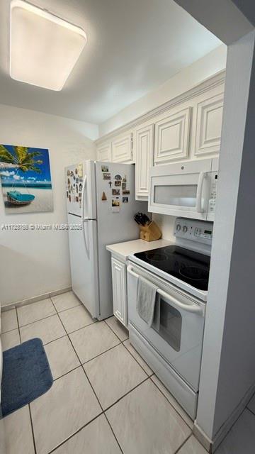 kitchen with white appliances and light tile patterned flooring