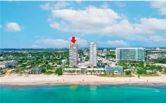 bird's eye view featuring a water view and a view of the beach