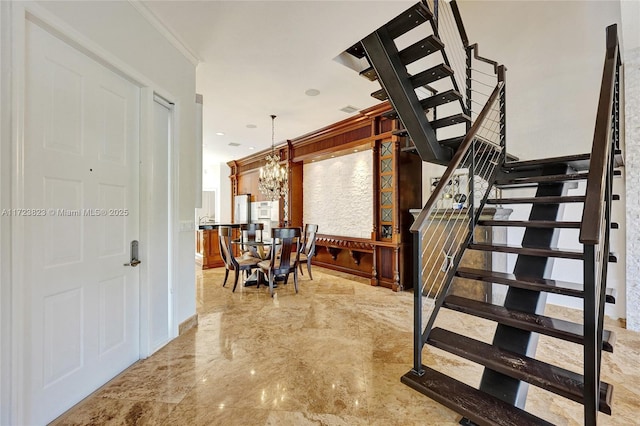 stairs featuring ornamental molding and a notable chandelier