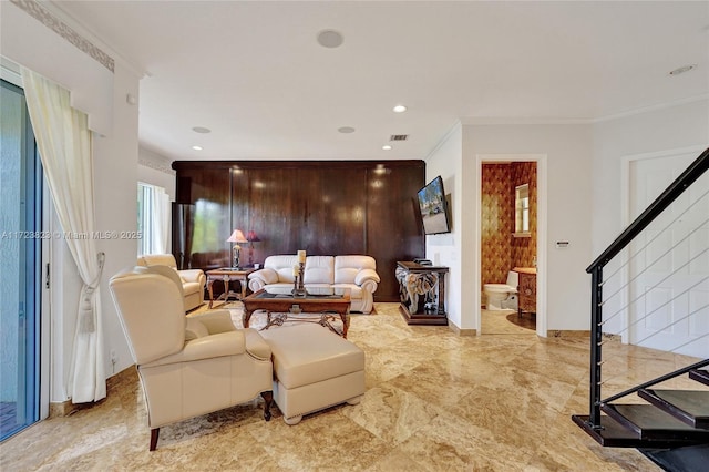 living room with wood walls and ornamental molding