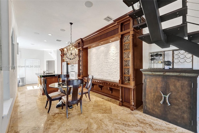 dining room with ornamental molding and a notable chandelier