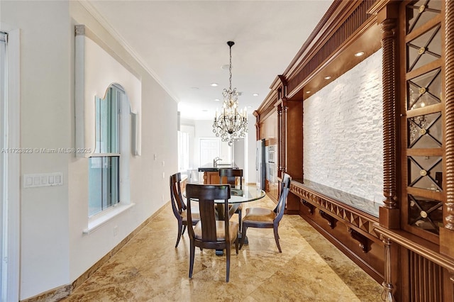 dining room with a chandelier, crown molding, and sink