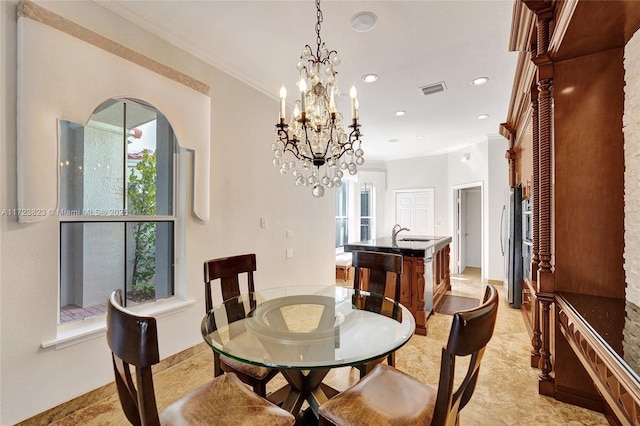 dining room with an inviting chandelier, crown molding, and sink