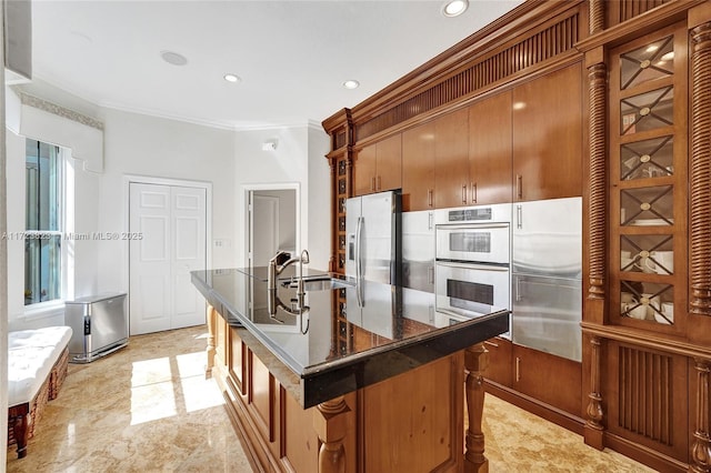 kitchen featuring a kitchen breakfast bar, stainless steel built in fridge, sink, stainless steel refrigerator with ice dispenser, and multiple ovens