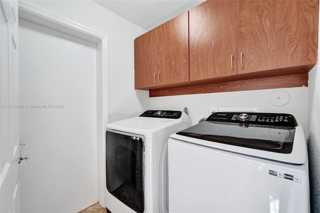 clothes washing area with cabinets and independent washer and dryer