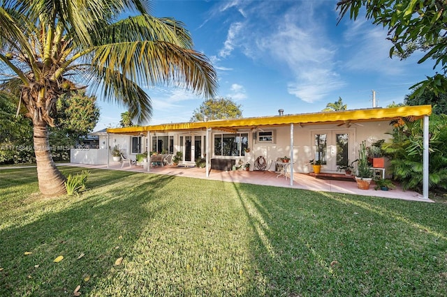 rear view of property featuring french doors, a yard, and a patio