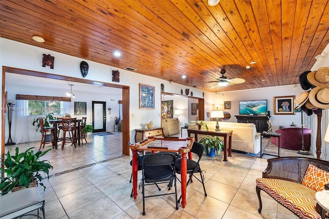 dining space featuring ceiling fan, light tile patterned floors, and wooden ceiling