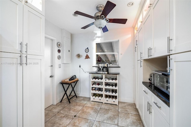 interior space featuring white cabinets, light tile patterned floors, and ceiling fan