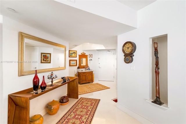 hallway with sink and light tile patterned flooring