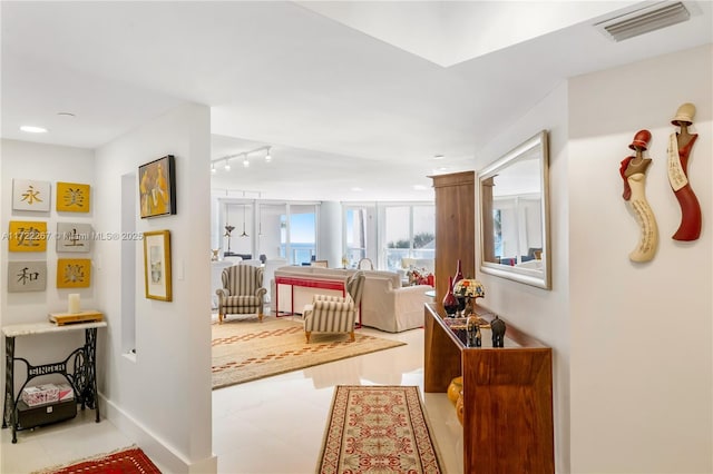 hall featuring light tile patterned floors and track lighting