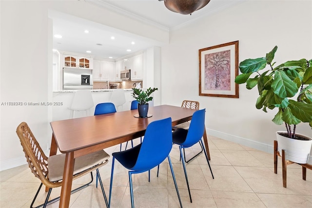 tiled dining room featuring ornamental molding